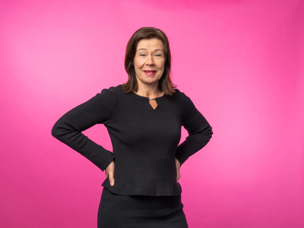 Marjo Lapatto smiling with pink background