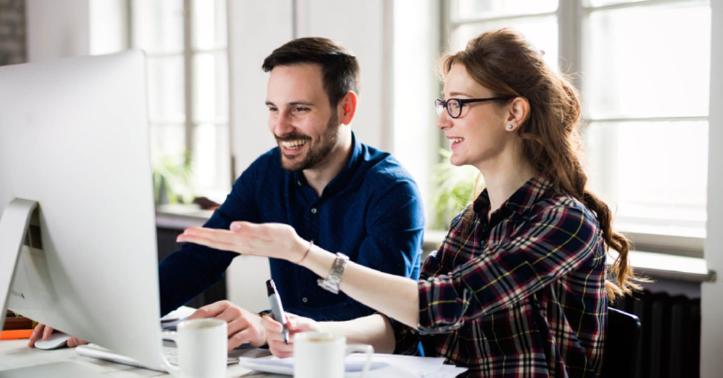 Man and woman discussing in front of a computer